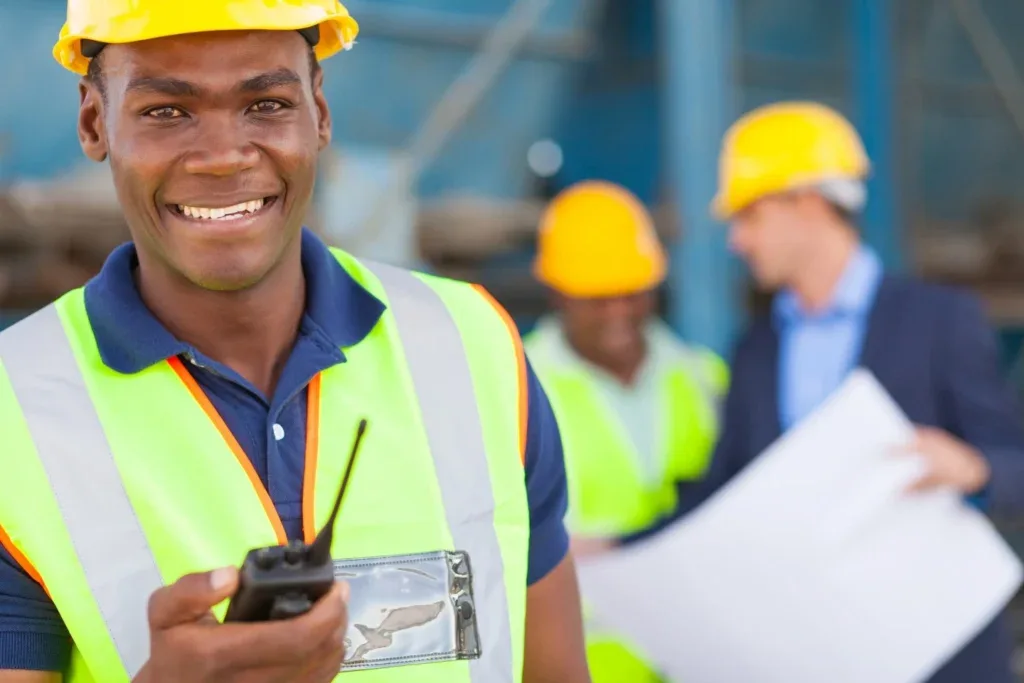 Workers wearing hard hats and high-visibility clothing at a job site